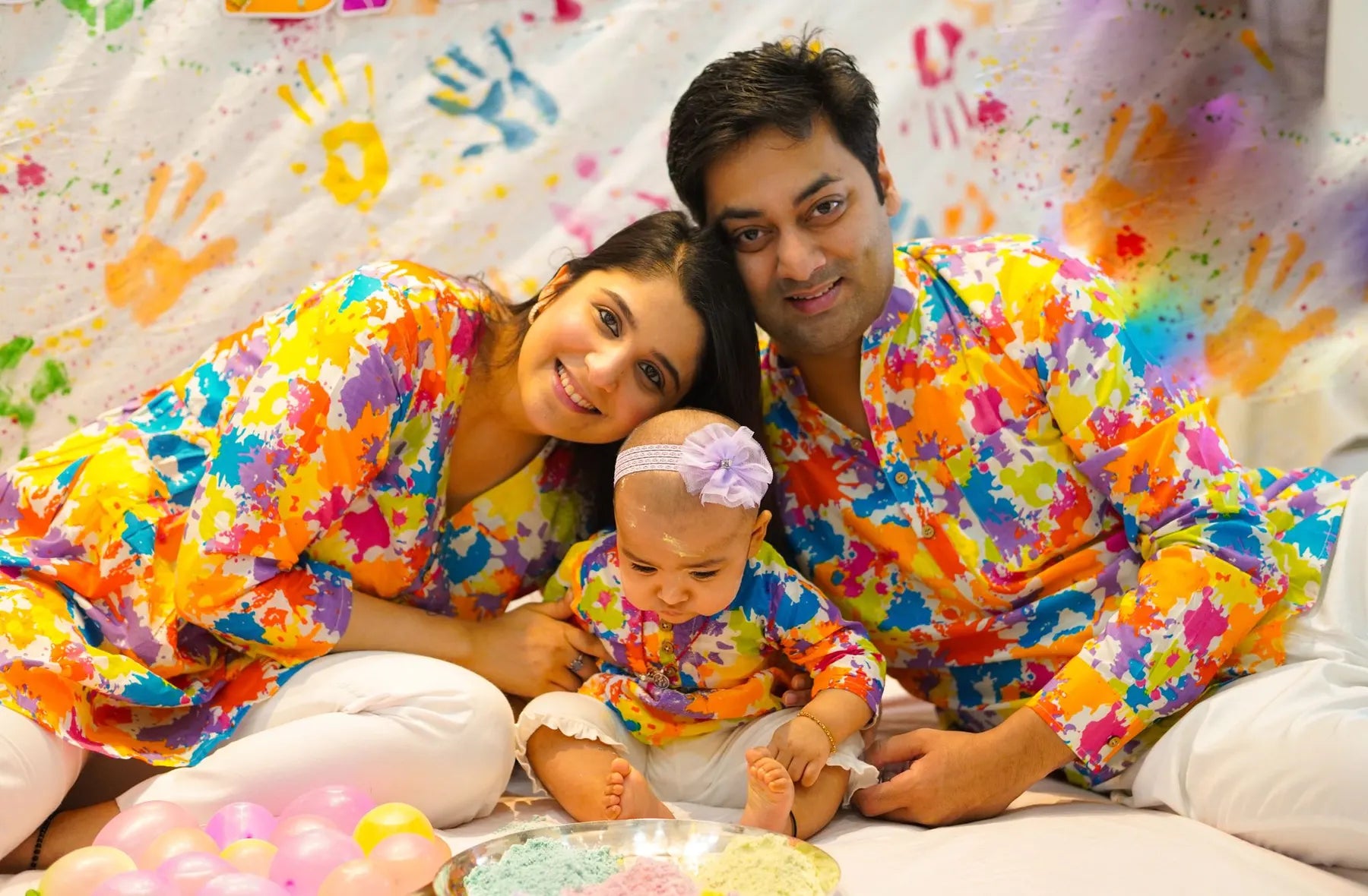 Mamá, papá y su bebé con camisas de colores