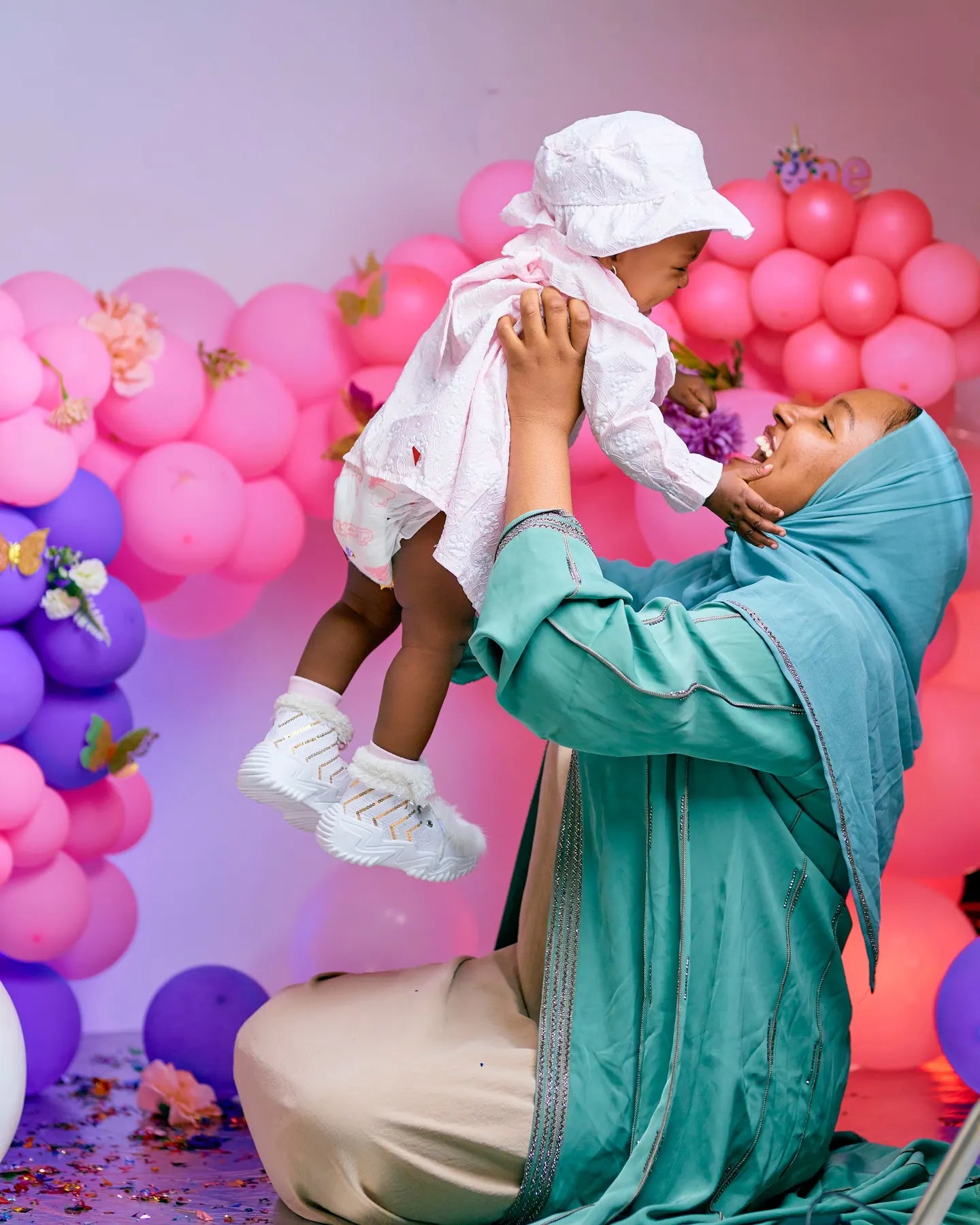 Mamá levantando a su bebé entre globos